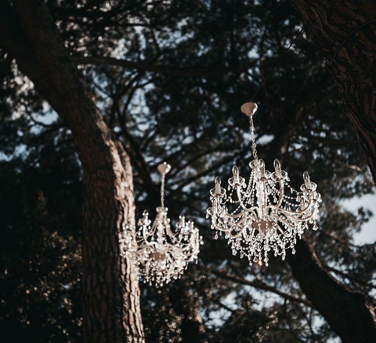 Chandeliers hanging from the tree at black and white wedding in Tuscany