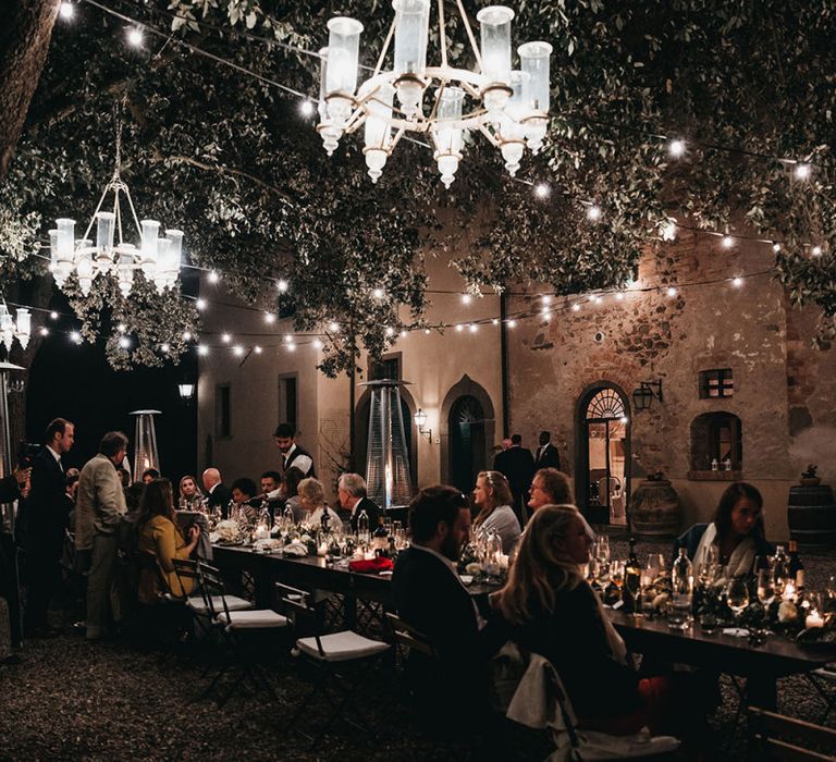 Reception lit up with festoon wedding lighting and chandeliers