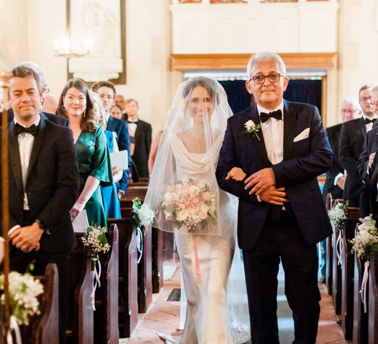 Bride walks down the aisle at church ceremony