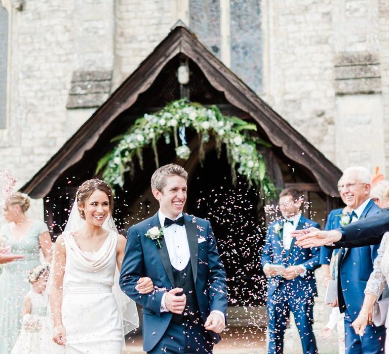 Confetti exit under flower arch at church