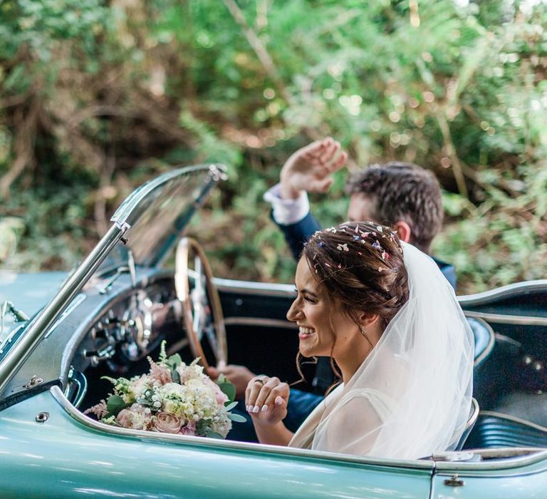 Bride and groom in vintage wedding car on their way to Four Seasons Hampshire