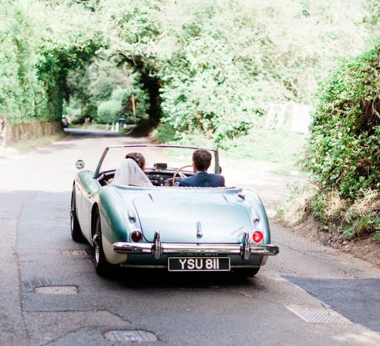 Bride and groom on their way to Four Seasons Hampshire in wedding car