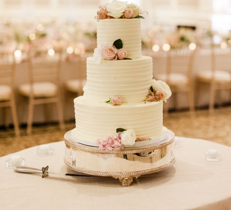 White wedding cake with pink flower decor