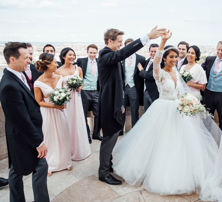 Bridal Party Portrait with Bride in Pergola Rosa Clara Princess Wedding Dress Being Twirled By Her Groom