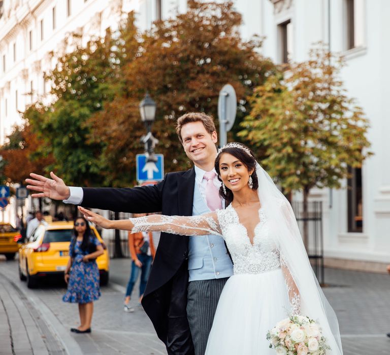 Bride in Pergola Rosa Clara Princess Wedding Dress and Groom in Traditional Morning Suit Catching a Cab