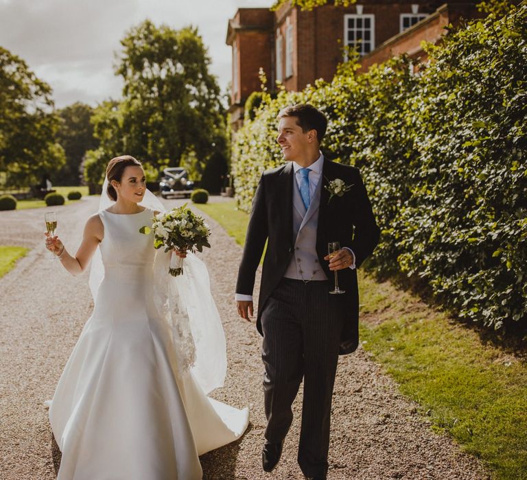 Bride and groom walking through the grounds of their Shropshire wedding venue, Iscoyd Park