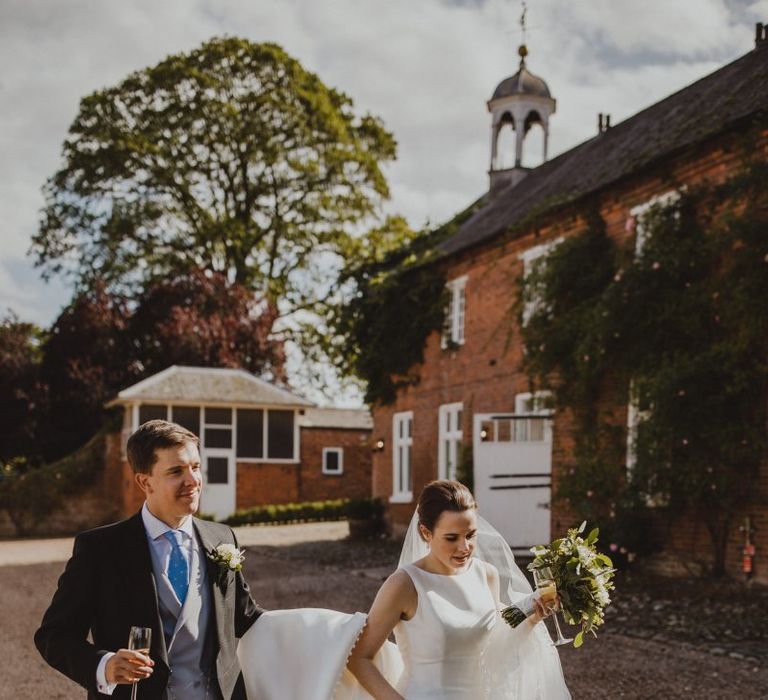 Groom helping his bride with her train