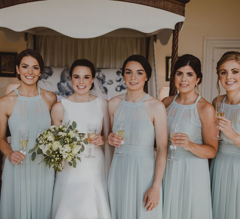 Bridal party portrait with bridesmaids in pale green halterneck dresses