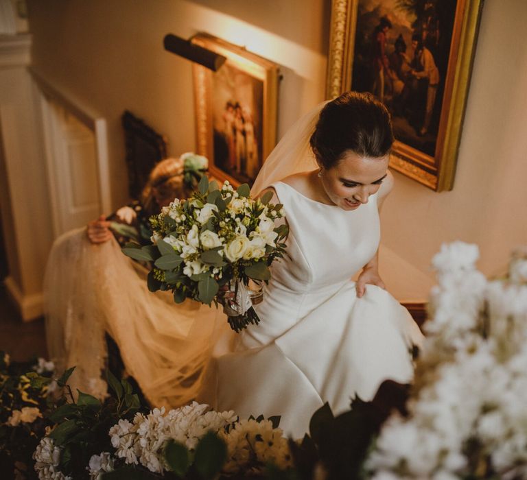 Bride in Pronovias wedding dress walking up the stairs at Shropshire wedding venue, Iscoyd Park