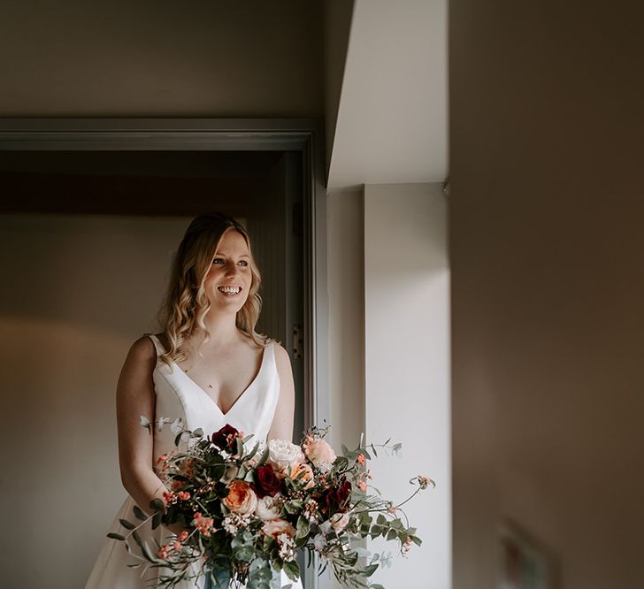 Bride in satin dress with large wedding bouquet