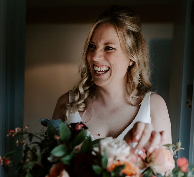 Bride with large bouquet during preparations for barn wedding