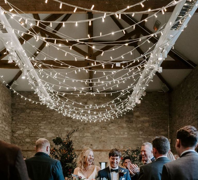 Bride and groom walk down the aisle at ceremony with unplugged wedding sign