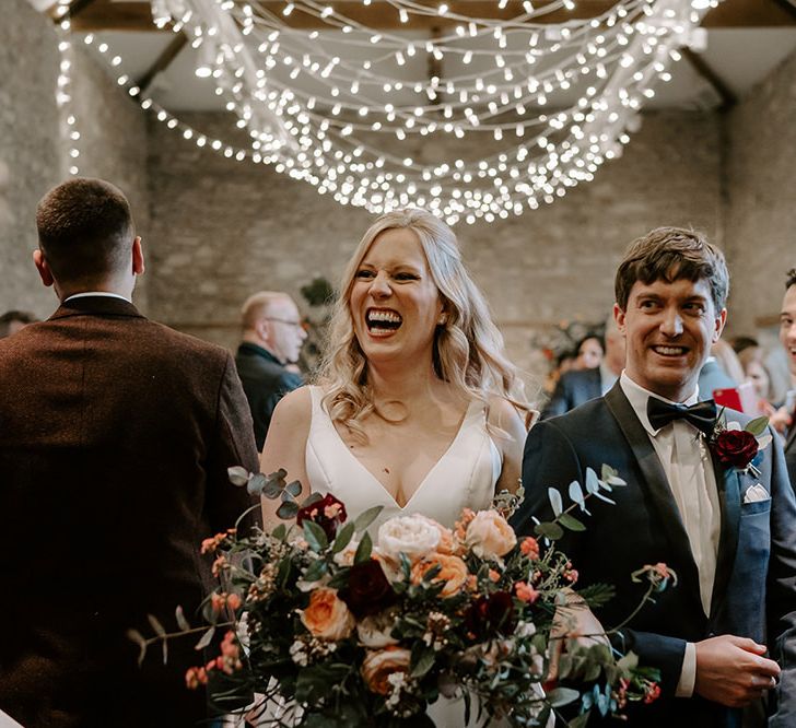 Newlywed bride and groom at ceremony with unplugged wedding sign