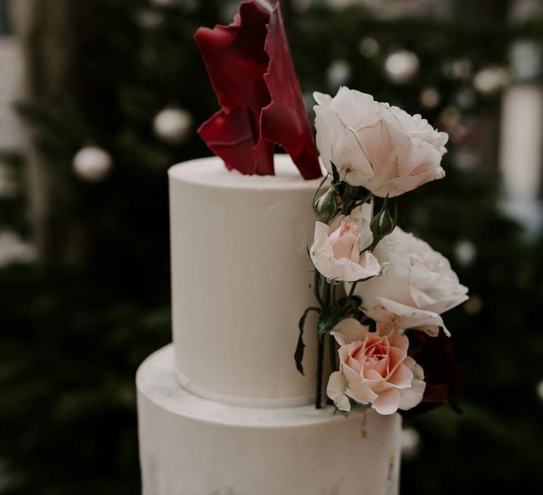 Marble wedding cake with flower decor at wedding with unplugged wedding sign