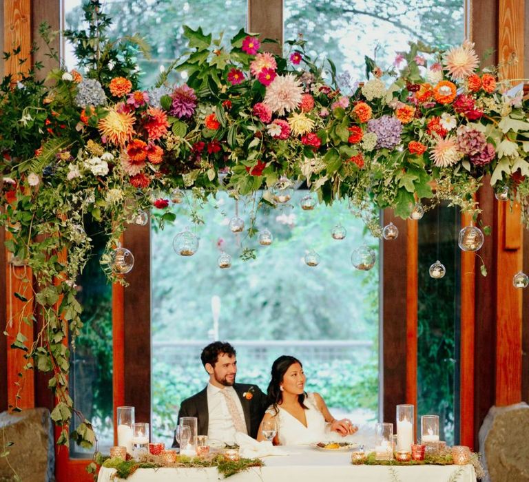 Bride and groom sitting at their sweetheart table