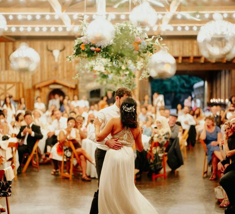 Bride and groom first dance with bride in racerback wedding dress