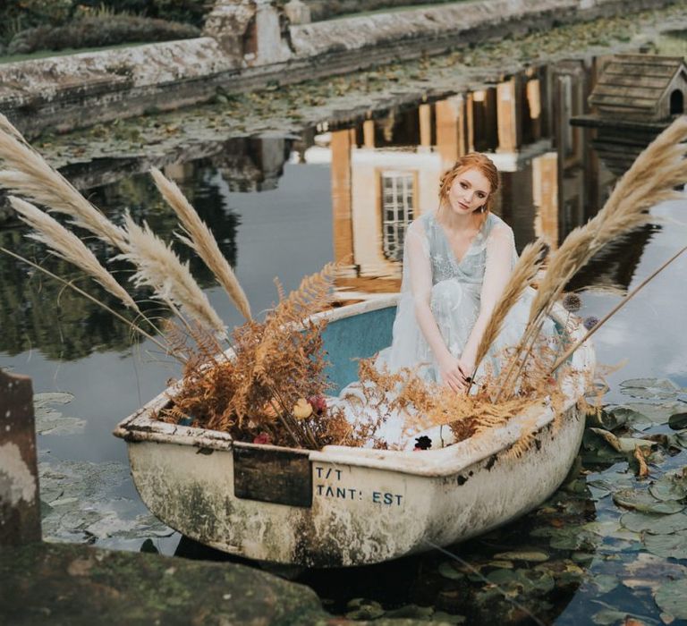 Bride sitting in boat at Stoke Park Pavillions