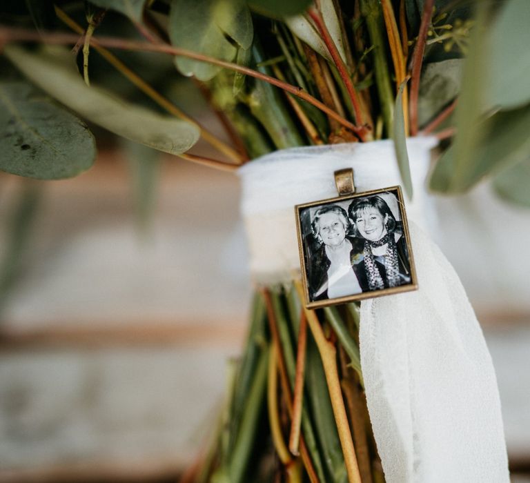 Precious photograph on bouquet ribbon at outdoor wedding