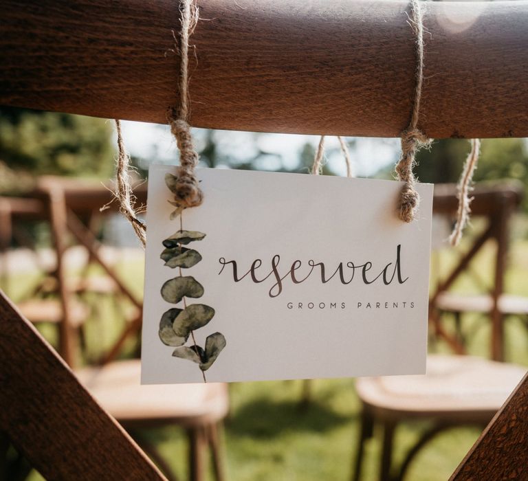 Wedding chair sign at outdoor ceremony for tipi wedding with donut wall and grazing table