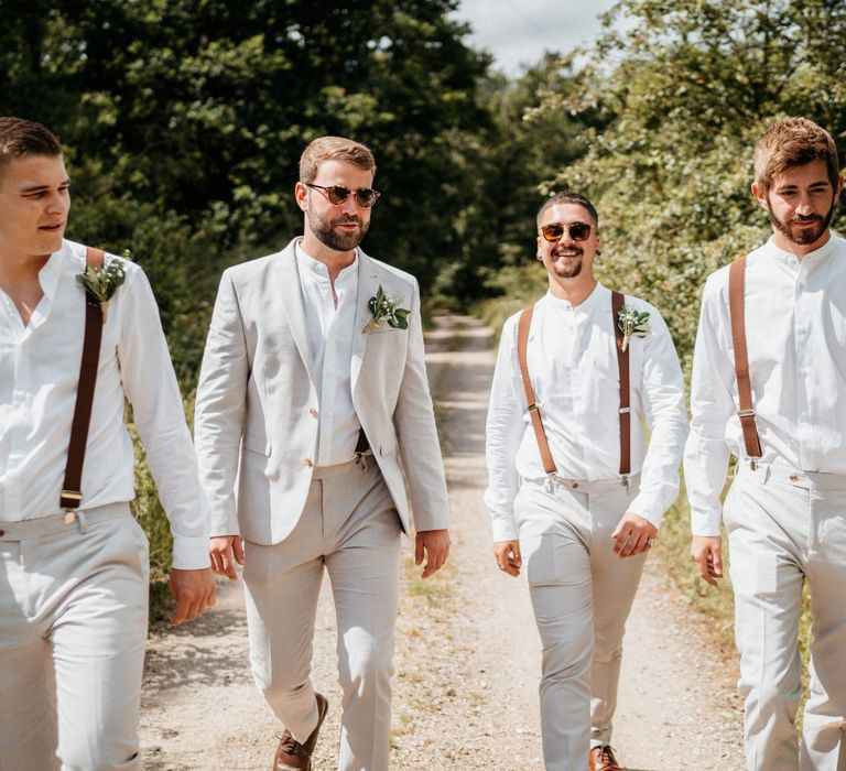 Groom and groomsmen in pale suits and braces