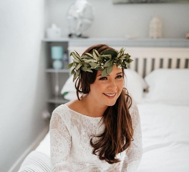 Foliage crown with lace bride dress at outdoor ceremony with donut wall