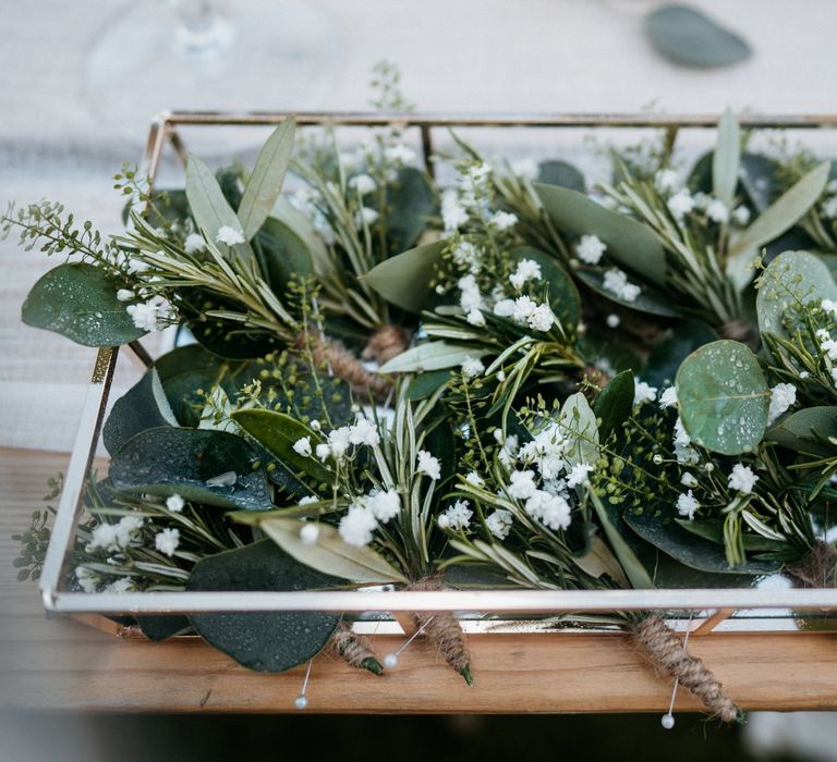 Foliage buttonholes for groom and groomsmen at boho outdoor wedding