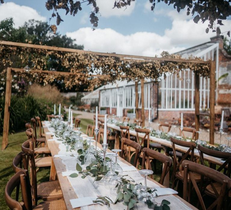 Wedding table set up at outdoor celebration with donut wall