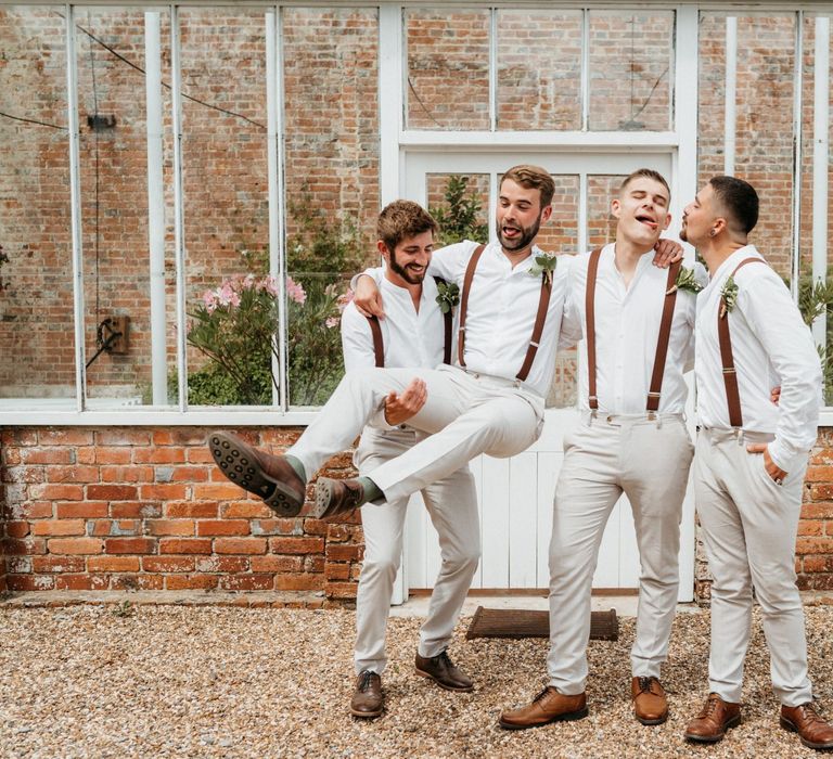 Groom and groomsmen in light coloured trousers with braces