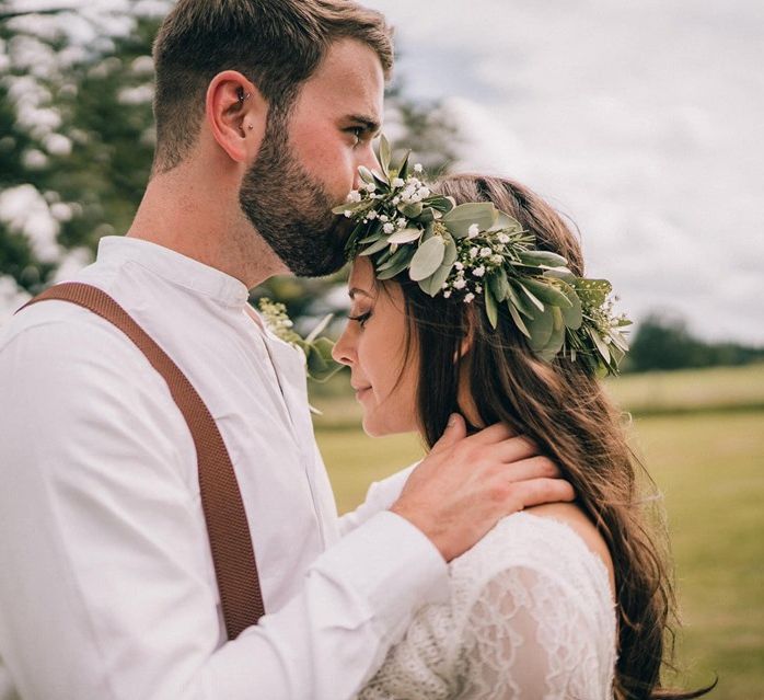 Bride wears foliage crown at outdoor wedding with donut wall