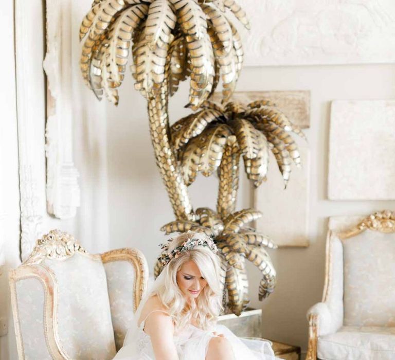 Bride puts on wedding shoes at whimsical wedding with Hayley Paige bride dress