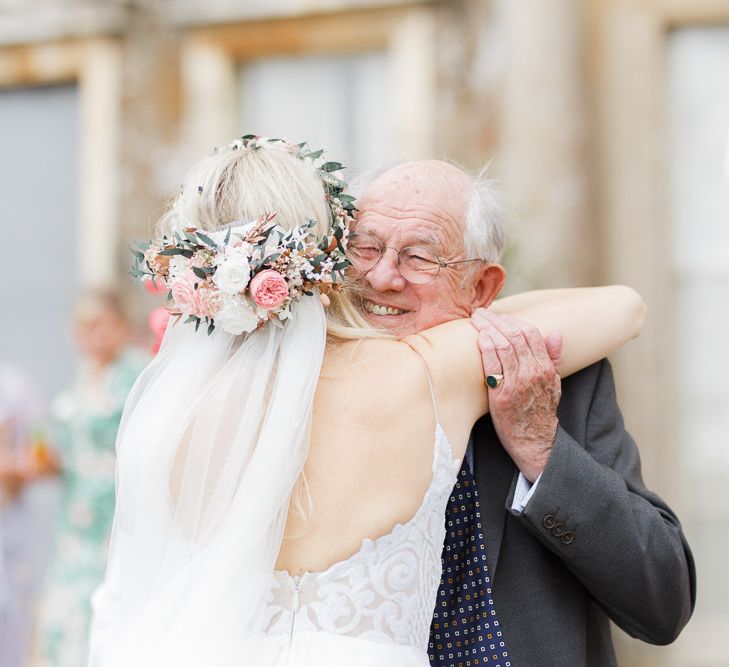 Bride wears flower crown and veil to greet guests