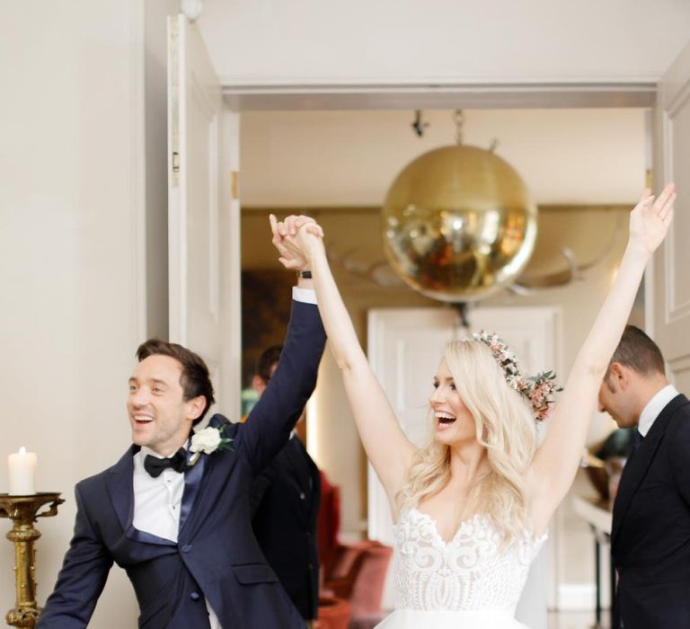 Bride and groom celebrate as they enter the wedding breakfast as husband and wife