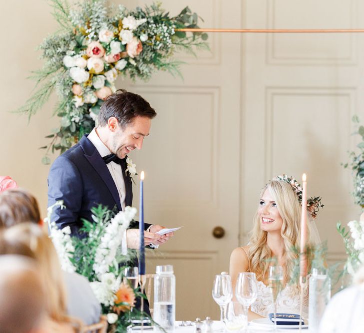 Groom makes a wedding speech with copper piping and flower decor