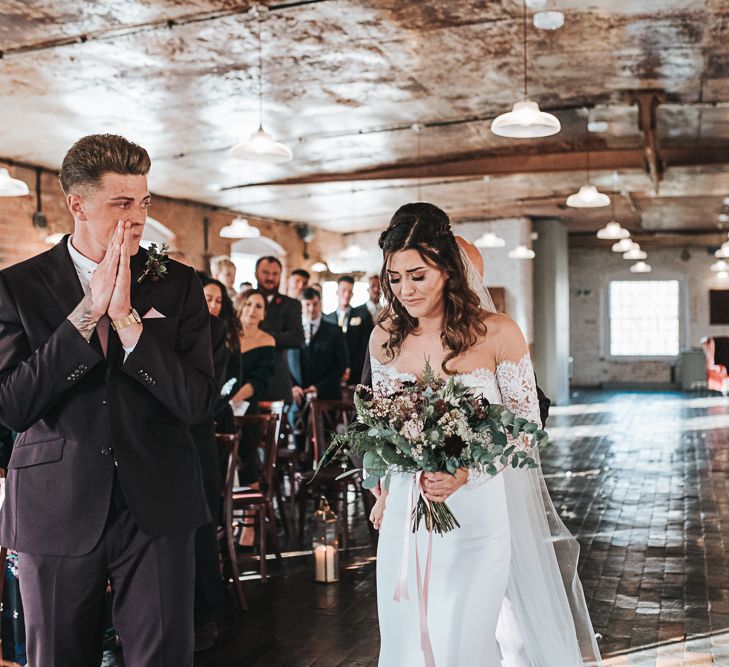 Emotional Bride in Bardot Wedding Dress and Groom in Moss Bros. Suit as they Meet at the Altar