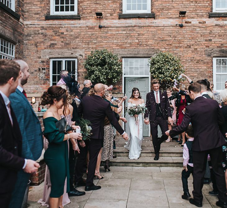 Confetti Moment with Bride in Pronovias Dracma Bardot Wedding Dress and Groom in Tailor Me Moss Bros. Suit