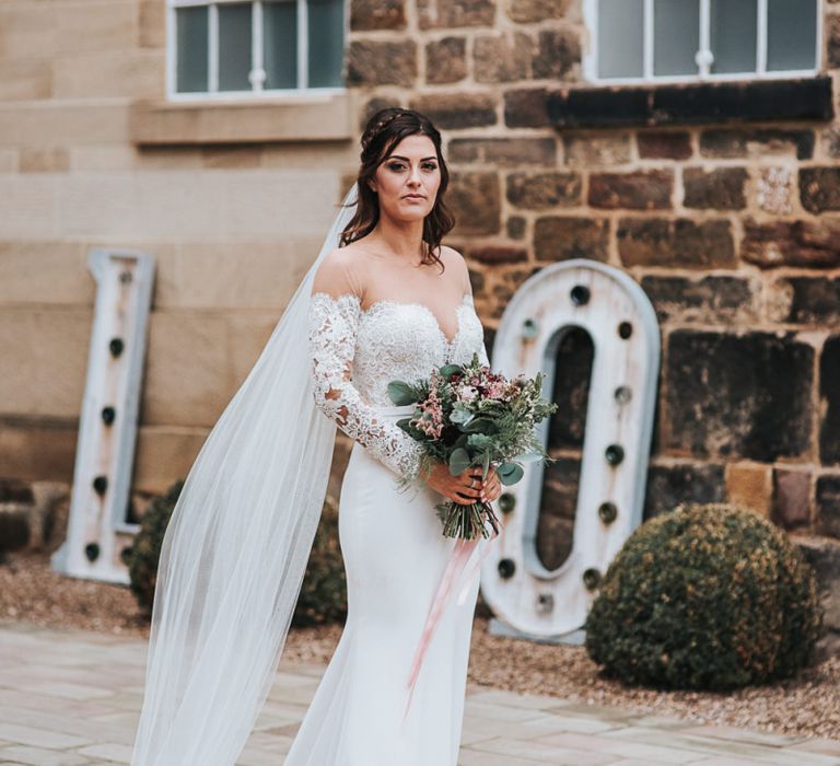 Bride in Lace Pronovias Dracma Bardot Wedding Dress Holding Her Winter Wedding Bouquet