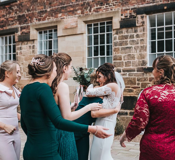 Bride in Pronovias Dracma Bardot Wedding Dress Hugging Her Friends