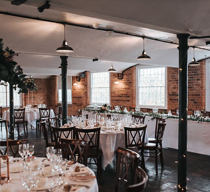 Wedding Reception Decor at Industrial Venue The West Mill in Derbyshire with Copper Centrepieces and Foliage Floral Arrangements