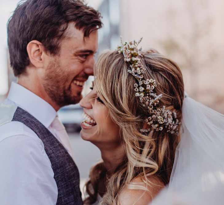 Smiling Bride with Loose Waves and Flower Crown with Groom in Grey Waistcoat