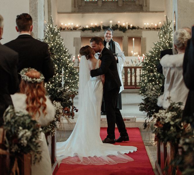 Church Wedding Ceremony with Bride in Essense of Australia Wedding Dress and Groom in Marks and Spencer Suit Kissing at the Altar