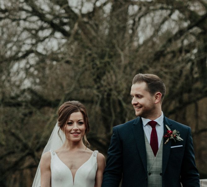 Bride in Essense of Australia Wedding Dress and Cathedral Veil and Groom in Marks and Spencer Suit