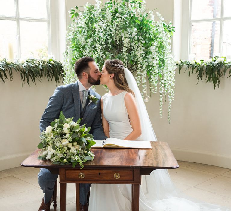 Bride and Groom Sitting at the Altar Signing the Register