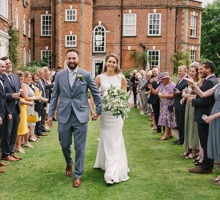 Confetti Moment with Bride in Pronovias Wedding Dress and Groom in Grey Suit