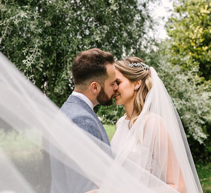 Bride and Groom Kissing with the Brides Veil Blowing in the Wind