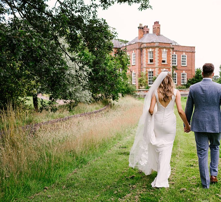 Bride in a Fitted Pronovias Wedding Dress with Button Back and Groom in Light Grey Wedding Suit