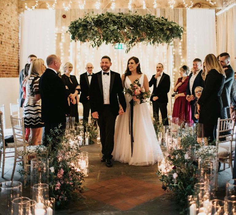 Foliage chandelier above newlyweds