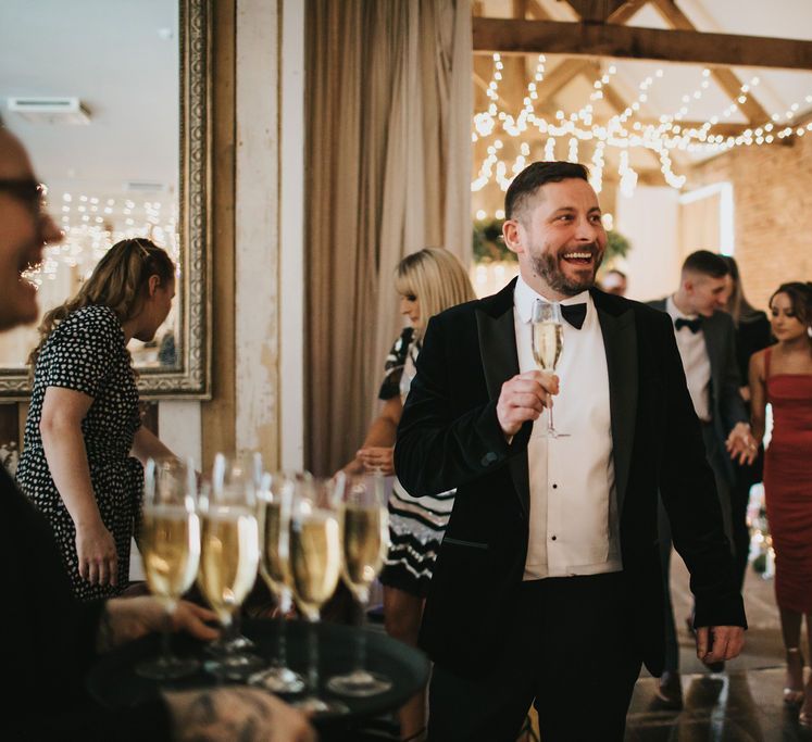 Groom enjoys a glass of champagne after Healing Manor wedding ceremony