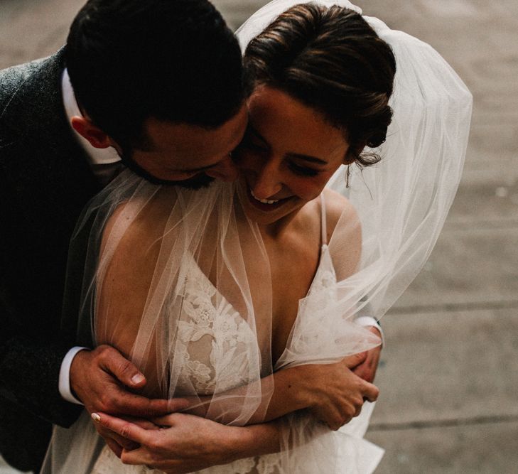 Bride in Hayley Paige Wedding Dress and Groom in Walker Slater Suit Embracing