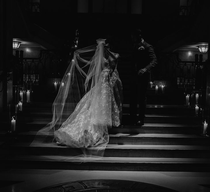 Bride in Hayley Paige Wedding Dress and Groom in Wool Walker Slater Suit Standing on a Candle Lit Staircase