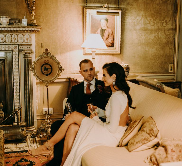 Bride and Groom Relaxing on The Sofa Showing Bride Split  Design in Her Dress